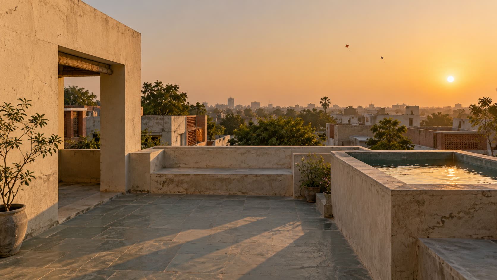 A flat roof terrace at golden hour in January, with kites far away in the hazy sky.